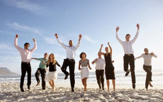 Nine businessmen and women jumping on beach, smiling